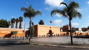 a building with palm trees in front of a street at Beachside Apartment in Mohammedia