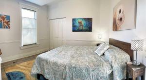 une chambre avec un lit et un tableau au mur dans l'établissement The Elm Tree Cottage in the Sugarhouse District, à Salt Lake City