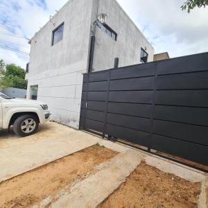 a white truck parked in front of a black fence at Comodo Dpto bien equipado cerca de Aeropuerto y COP Comité Olímpico Py in Luque