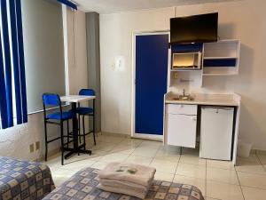 a small room with a kitchen and a table at Hotel H Americas in Guadalajara