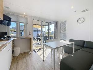 a kitchen and living room with a table and a dining room at Mobil-home Confort 4 pers, plage à 200m, piscine chauffée, terrasse Sud, parking, wifi inclus - FR-1-361A-81 in Jullouville-les-Pins
