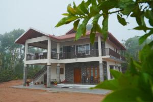 a house with a porch and a balcony at Coffee hills Homestay- near etthina buja, devaramane, bettadhabiraveshvara temple in Mudigere
