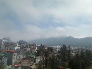 a city with buildings and mountains in the background at Nhà Nghỉ Đức Anh in Sa Pa +4 photos