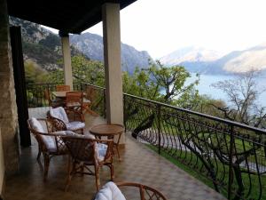 balkon z krzesłami i stołami oraz widokiem na wodę w obiekcie Villa Panoramica w Tremosine Sul Garda