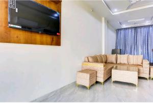 Una sala de estar con un sofá y un televisor de pantalla plana. en Hotel Himalaya, en Kota
