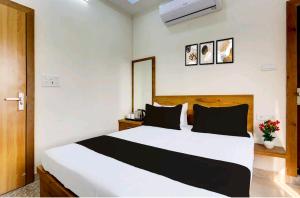 1 dormitorio con 1 cama blanca grande con almohadas negras en Hotel Himalaya, en Kota 2 fotos más