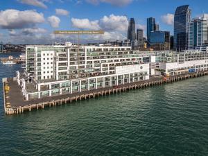 Un gran edificio blanco al lado de un cuerpo de agua. en Waterfront Escape, Princes Wharf with Carpark, en Auckland