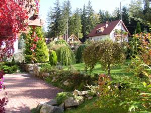 un jardin avec une allée en briques devant une maison dans l'établissement Willa Szyszka, à Karpacz