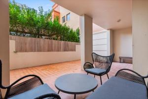 悉尼Bright Inner-West Stay with Pool Access的一个带桌椅的庭院和围栏