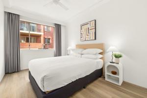 悉尼Bright Inner-West Stay with Pool Access的一间带大床和窗户的白色卧室