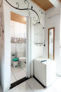 a bathroom with a toilet and a bird cage at POUSADA los SABABA in Morro de São Paulo +41 photos
