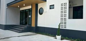 un edificio con una pianta in vaso di fronte di TharaD place a Samut Sakhon