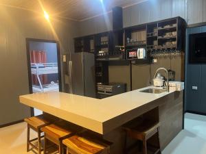 a kitchen with a counter with a sink and a refrigerator at Casa Briana in Uvita +9 photos