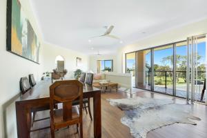 a dining room with a table and a couch at Solitary at Sandy in Sandy Beach