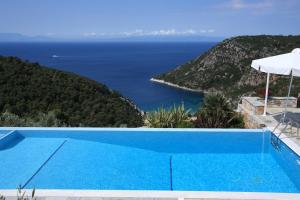 a swimming pool with a view of the ocean at Elies Houses in Agnontas