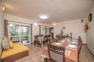 a living room with a table and a dining room at Onella in Yedapalli