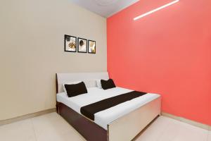een slaapkamer met een bed met een rode muur bij HOTEL O S.R GRAND INN in Sītāpur +21 foto's