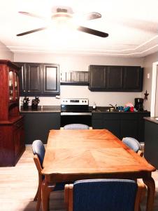 a kitchen with a wooden table with chairs and a kitchen with a stove at Sandy's House in Minden