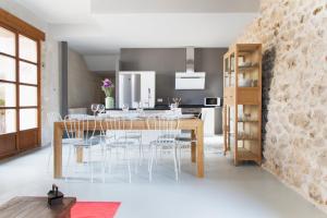 cocina y comedor con mesa de madera y sillas en Casa de Laura, en Aldeasoña