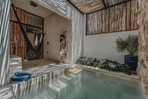 a man standing in a room next to a swimming pool at Casa Menara en Chuburna Puerto in Chuburná