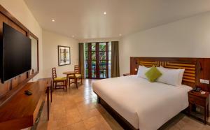a bedroom with a bed and a flat screen tv at The Warwick Fiji in Korolevu