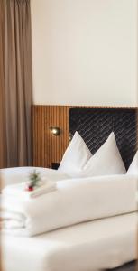 a bedroom with a bed with white sheets and pillows at Paradeis Apartments A19 in Mühlbach