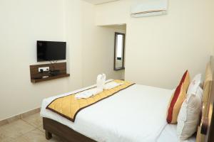 a bedroom with a bed with towels on it at Starwin Residency in Rāmanāthapuram +16 photos