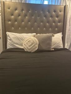 een bed met een bruin hoofdeinde en witte kussens bij Sunny Girasol Garden in Broadview