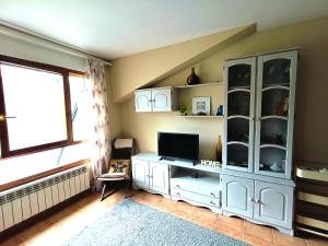 a living room with a white cabinet and a television at Apartamento con encanto in Jaca