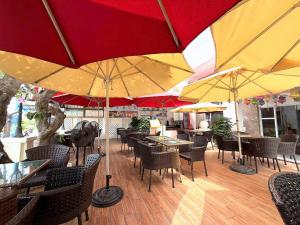 a restaurant with tables and chairs with umbrellas at Phoenix Hotel Vung Tau in Vung Tau