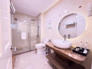 a bathroom with a sink and a shower and a mirror at Phoenix Hotel Vung Tau in Vung Tau