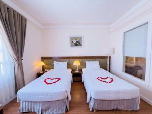 two beds in a room with hearts painted on them at Phoenix Hotel Vung Tau in Vung Tau