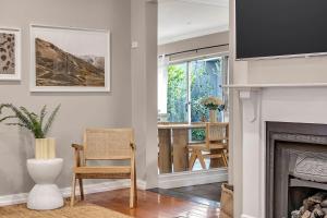 ein Wohnzimmer mit Kamin und Tisch in der Unterkunft 'Parkstone' Modern Elegance near CBD & Zoo in North Adelaide