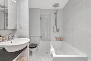 ein weißes Badezimmer mit Waschbecken, Badewanne und Toilette in der Unterkunft 'Parkstone' Modern Elegance near CBD & Zoo in North Adelaide + 12 Fotos