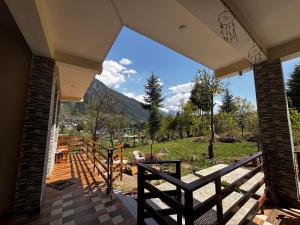 un porche de una casa con vistas a la montaña en By The Way, en Manali