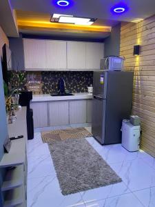 a kitchen with a refrigerator and a counter top at 3 Bedroom Condotel Ina Mansion Baguio City in Baguio