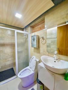 a bathroom with a toilet and a sink and a shower at 3 Bedroom Condotel Ina Mansion Baguio City in Baguio