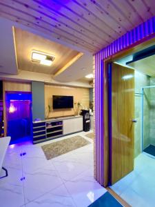 a living room with purple lighting and a sliding door at 3 Bedroom Condotel Ina Mansion Baguio City in Baguio