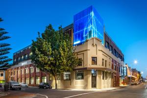a building with a blue glass facade on a street at Quest Fremantle in Fremantle