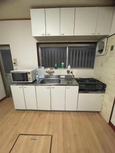 a kitchen with a sink and a microwave at 福苑李 in Osaka