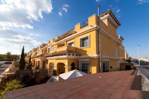 żółty dom na ceglanej drodze w obiekcie Merecido Descanso Sun Beach w mieście Torrevieja