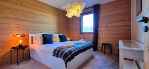a bedroom with a bed with a wooden wall at Les Flambeaux - Apartment with Panoramic View - Alp'in C in Châtel