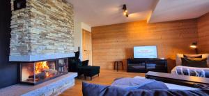 a living room with a fireplace and a tv at Les Flambeaux - Apartment with Panoramic View - Alp'in C in Châtel