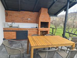 a patio with a table and chairs and a brick oven at The House in Corbi