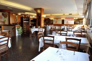 a restaurant with white tables and chairs in a room at Hotel Italia in Stradella