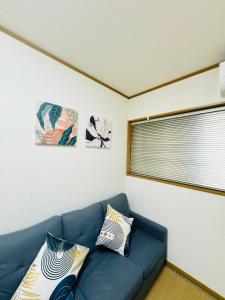 a blue couch in a living room with two pillows at 谷町の宿 in Osaka