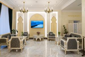 eine Lobby mit Stühlen und Tischen und einem Gemälde in der Unterkunft Al Anvar Halal Hotel by HotelPro group in Taschkent