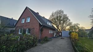 einem roten Backsteinhaus mit Auffahrt in der Unterkunft Haus am See - Urlaub im Herzen des Münsterlands in Steinfurt