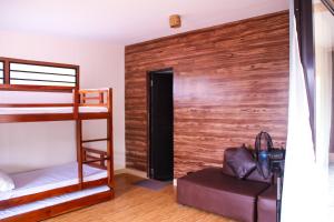 a bedroom with bunk beds and a wooden wall at Camote's Lake Retreat in Cavinti