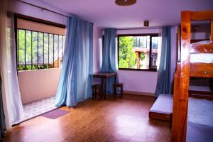 a bedroom with a bed and a window with blue curtains at Camote's Lake Retreat in Cavinti +21 photos